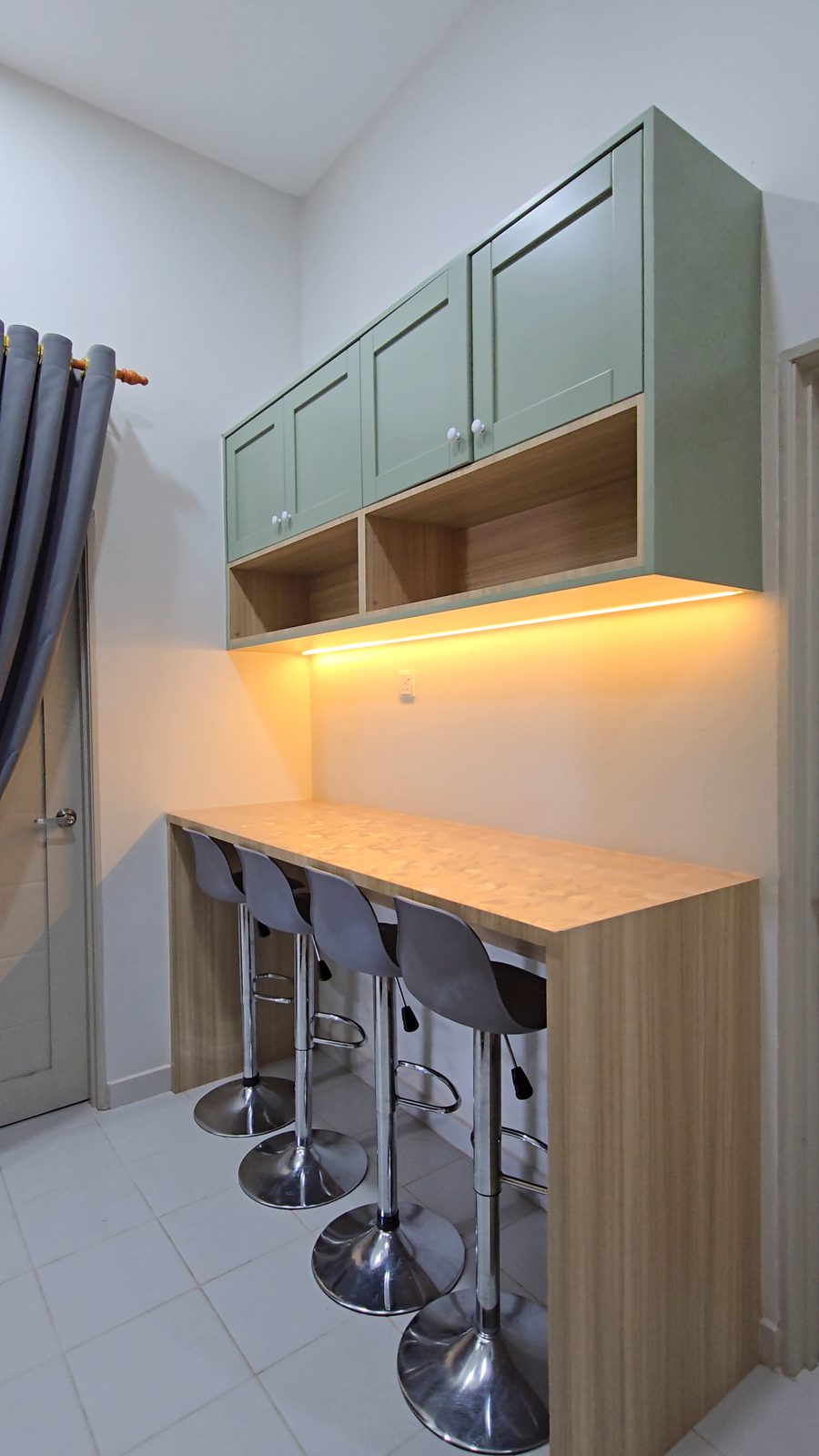 Sage-green bar counter with timber top and stools