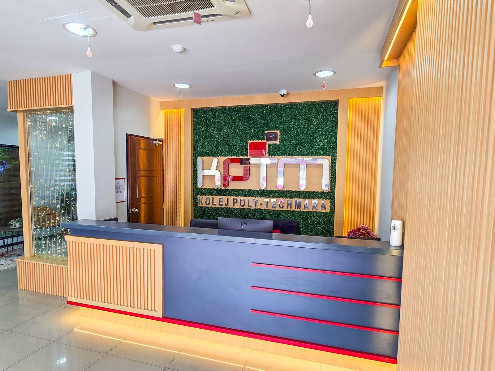 KPTM reception counter with fluted timber panelling and logo feature wall