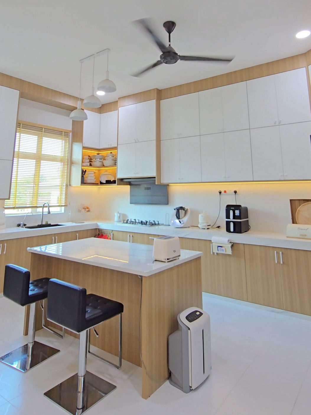 Kitchen with island and bar stools in oak and white