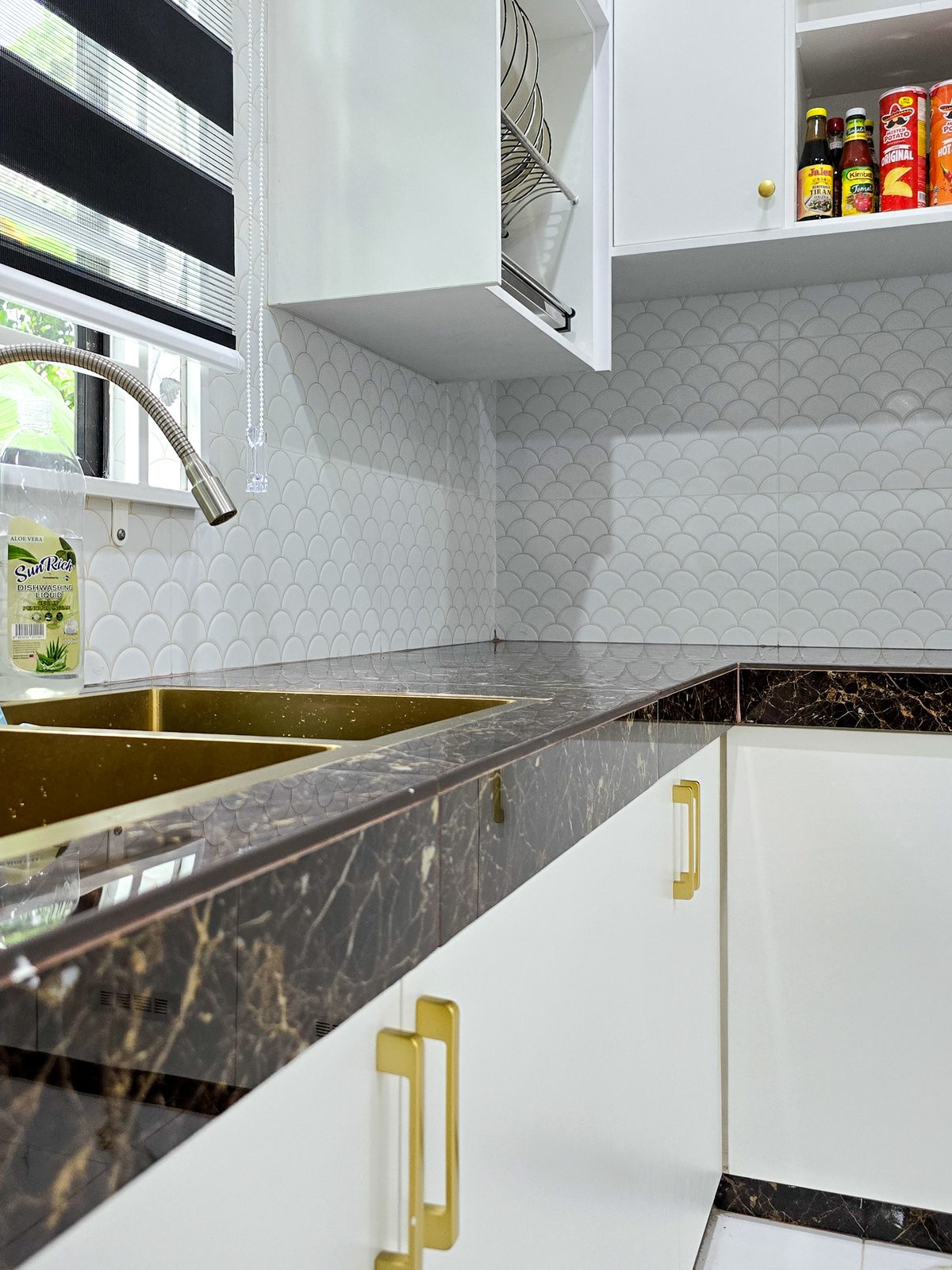 Marble countertop with mosaic backsplash and gold handles