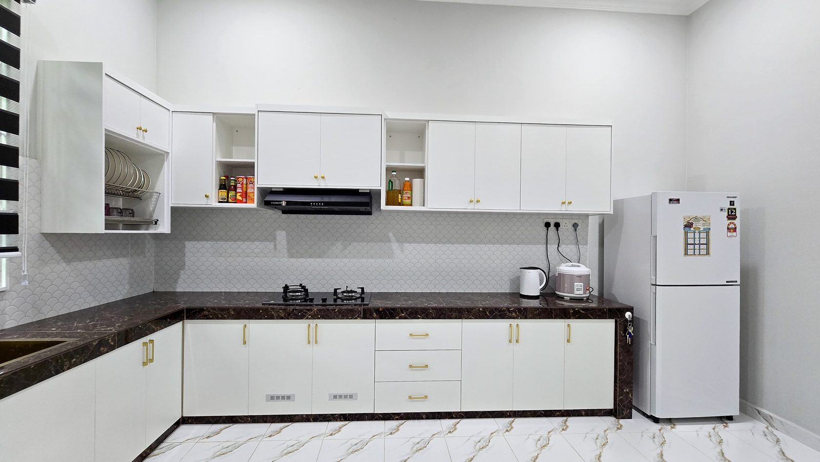 White L-shaped kitchen with dark marble countertop