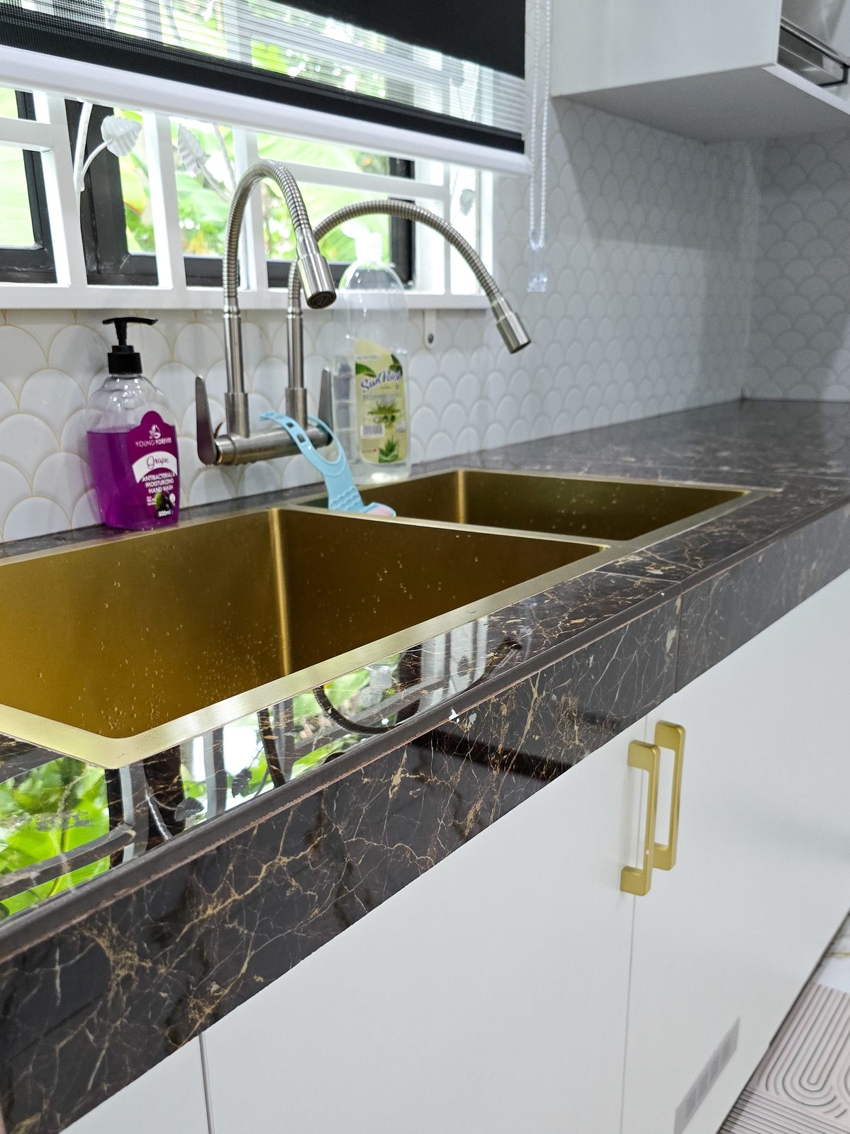 Brushed-gold sink set in dark marble countertop
